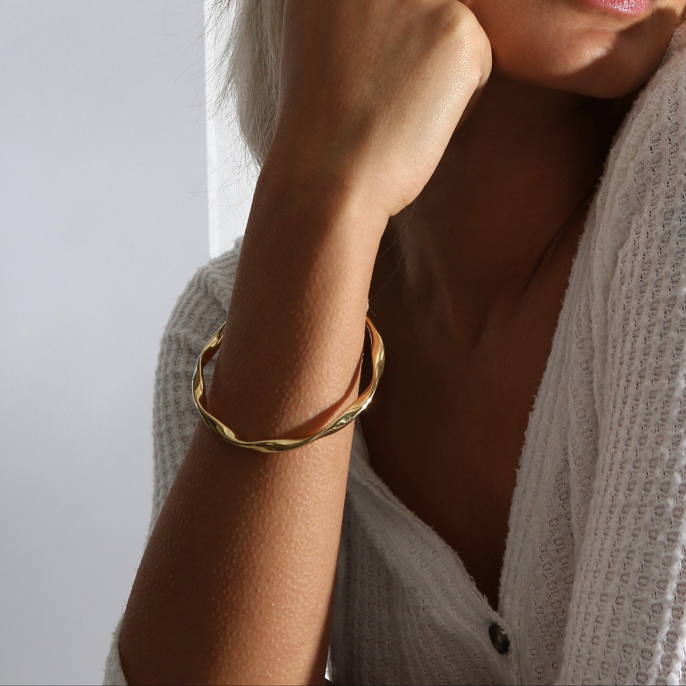 Model Wearing 18ct gold vermeil plate twisted bangle, Arm close up
